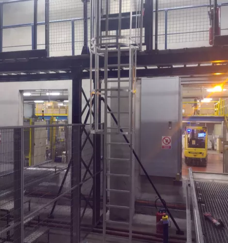 Échelle métallique verticale dans un espace de stockage avec plateforme