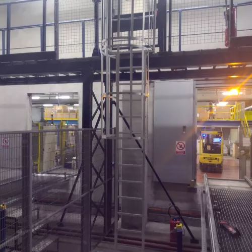 Échelle métallique verticale dans un espace de stockage avec plateforme