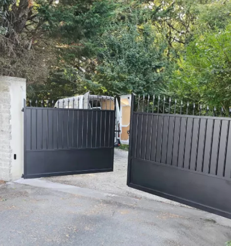 Détail du portail noir avec barreaux et panneaux en métal