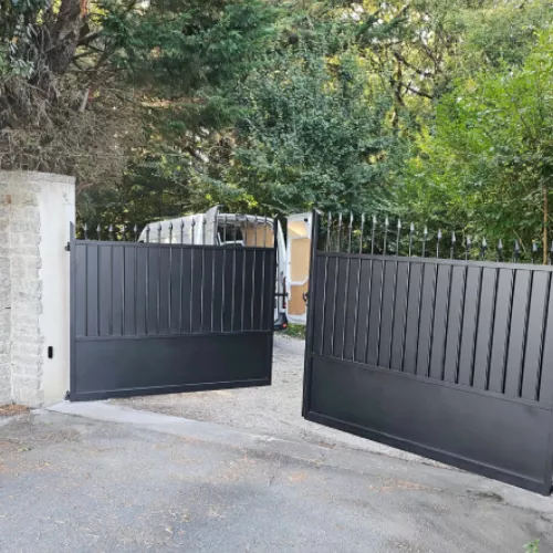 Détail du portail noir avec barreaux et panneaux en métal