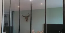 Séparation de pièce en verre avec cadre métallique noir et décoration moderne